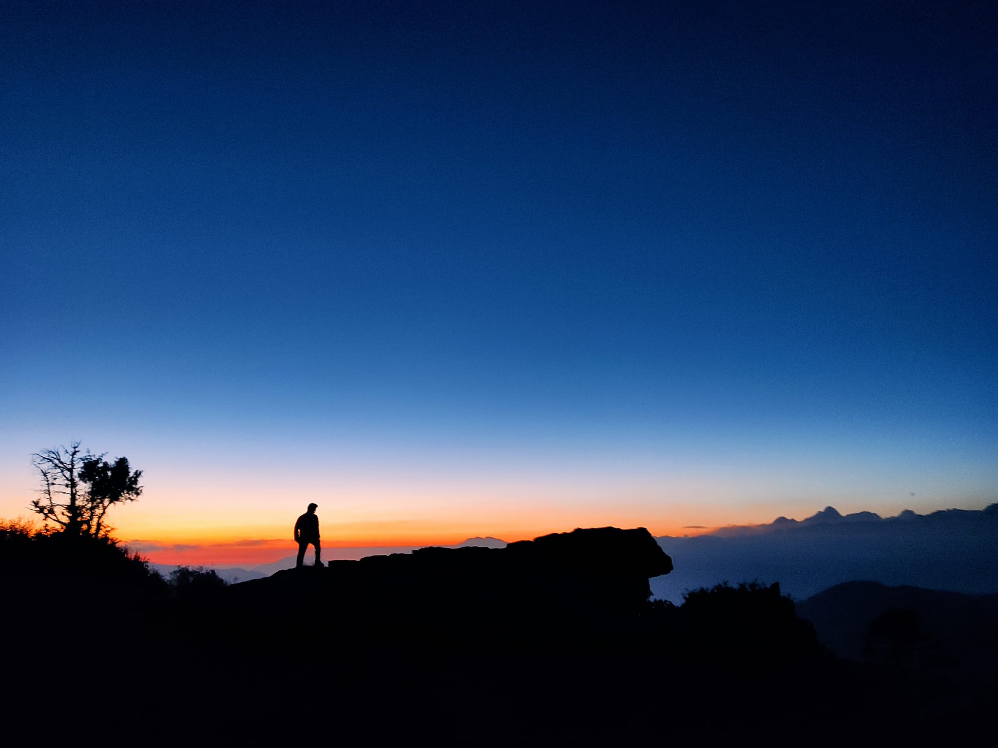 Silhouette at sunrise above the clouds